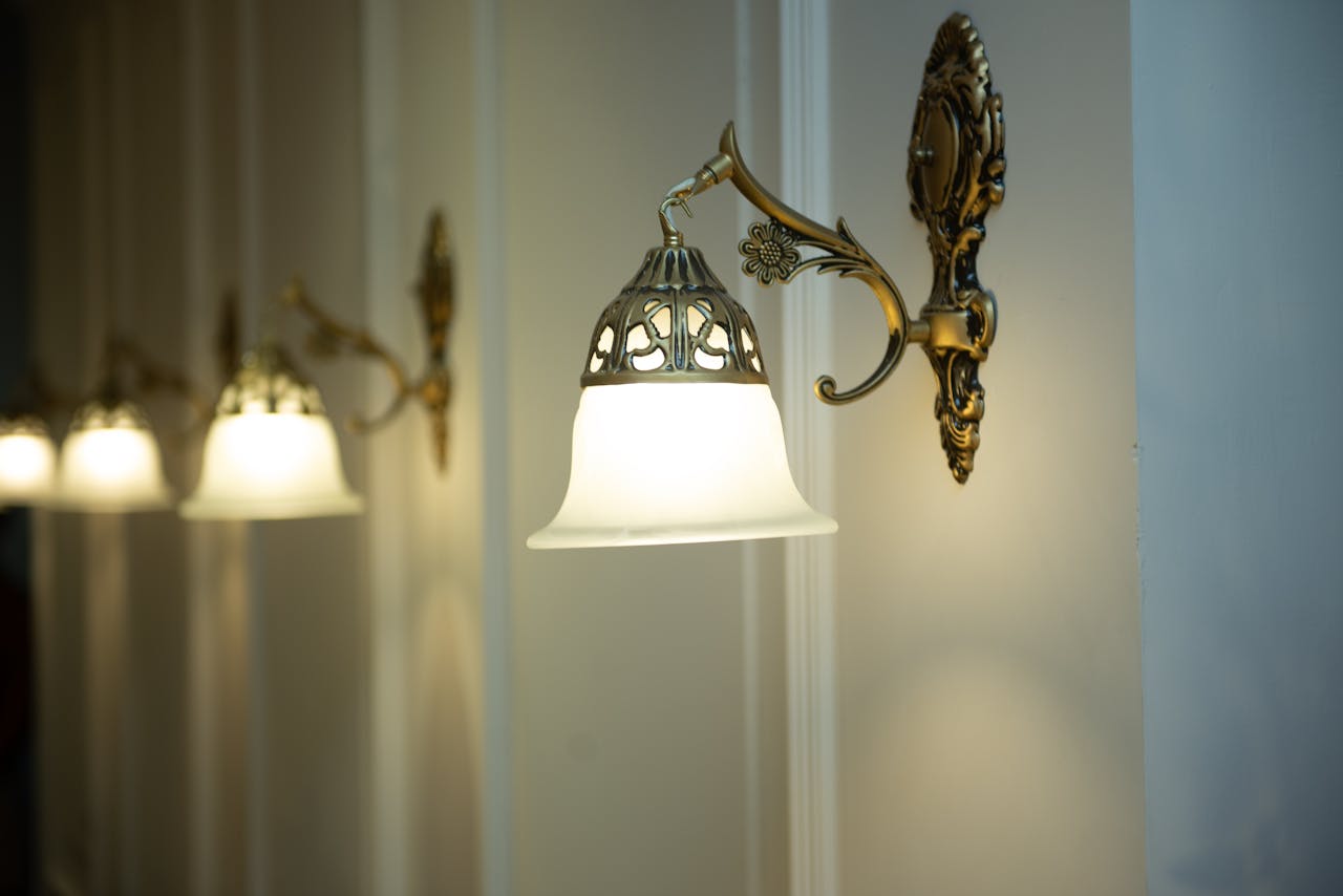 A row of vintage brass wall sconces with elegant frosted glass shades illuminating an indoor setting.